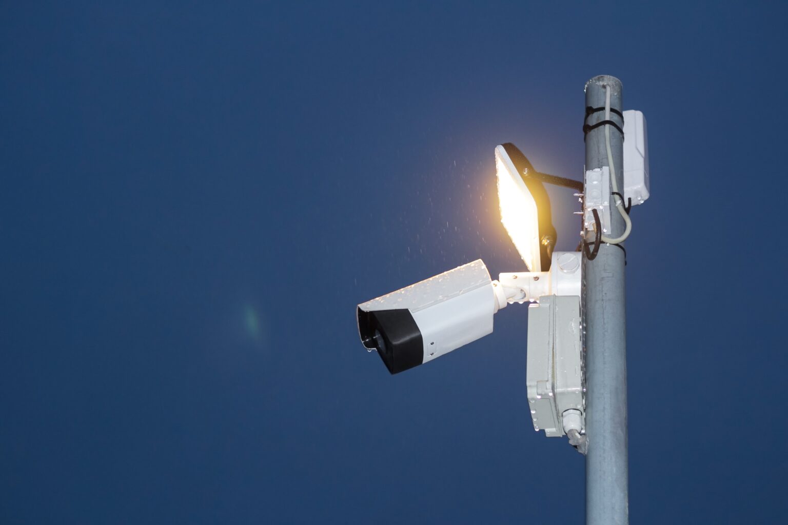 A security light and camera at the top of a pole