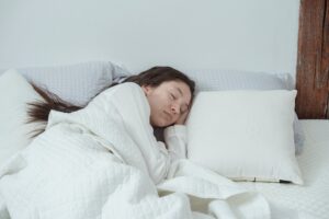 A woman asleep in a bed with white bed sheets