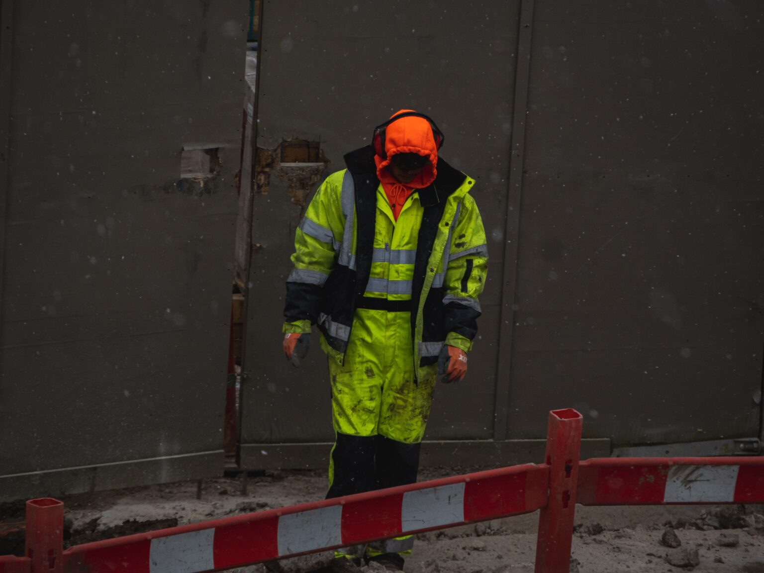 A man in hivis on a building site wearing Bluetooth Hearing Protection