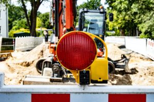 An LED Work Light with a digger in a construction site behind it