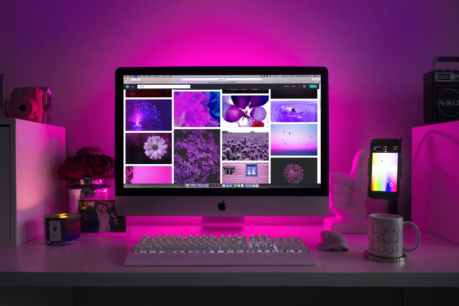 iMac on a desk with pink LED lighting behind it