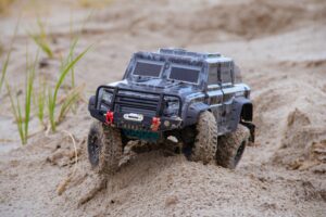 A closeup of an RC truck on a sandy beach