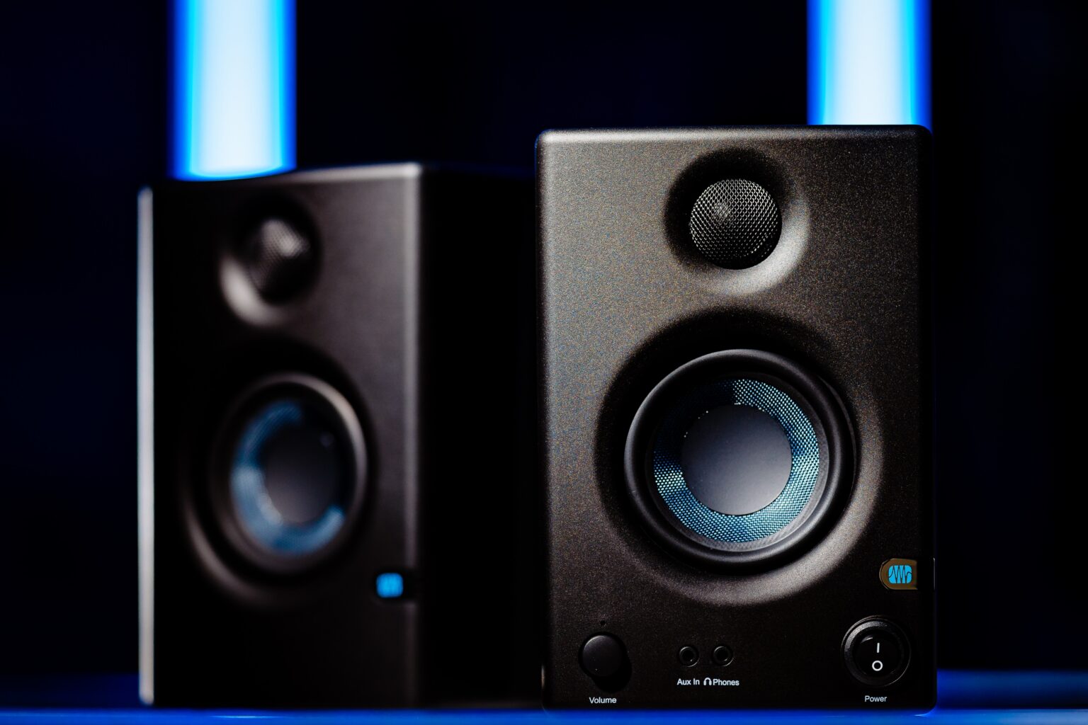 Closeup of 2 Bluetooth Garage Speakers with blue lighting in the background