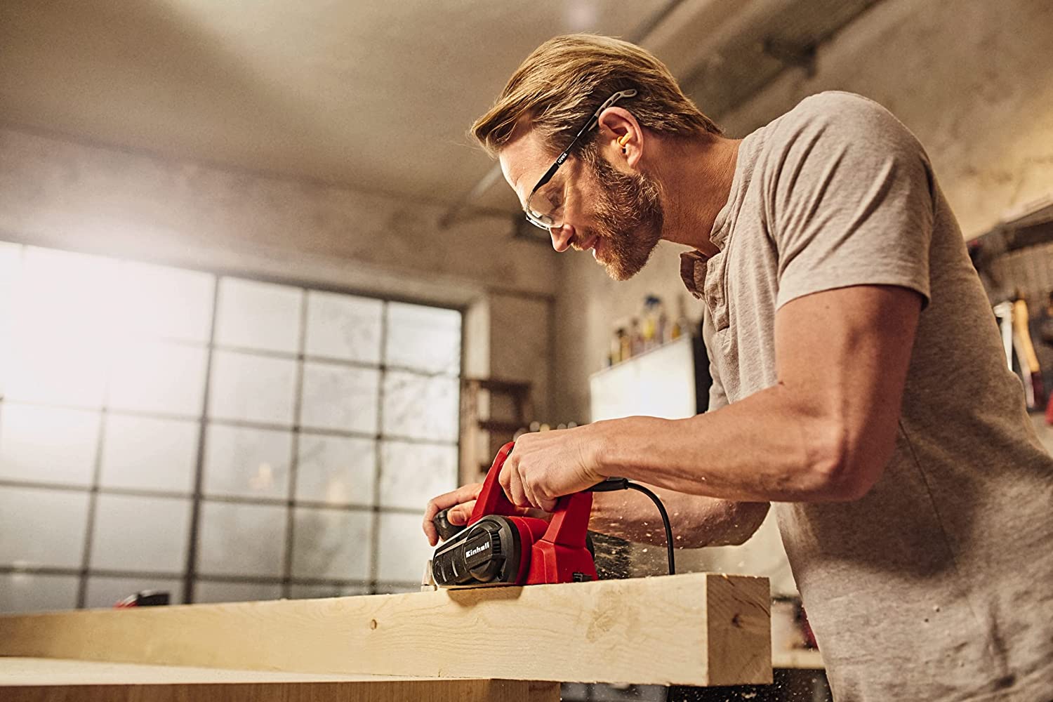 A man shaving wood with an Electric Planer