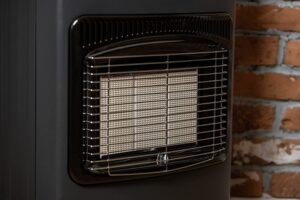 A closeup of Calor Gas Heater in front of a brick wall