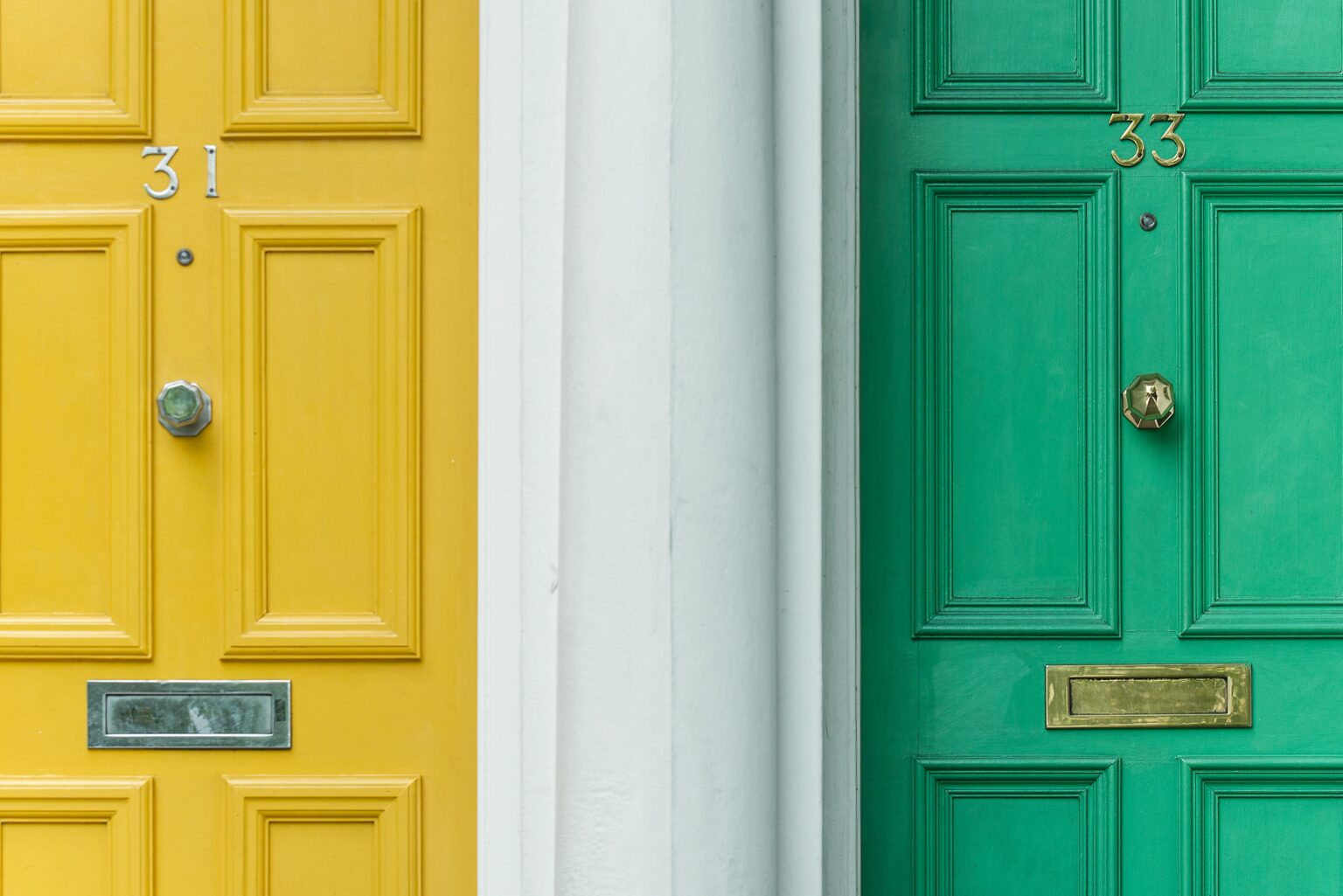 A yellow front door and a green front door next to each other