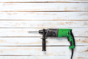 A Corded Hammer Drill on light wooden planks