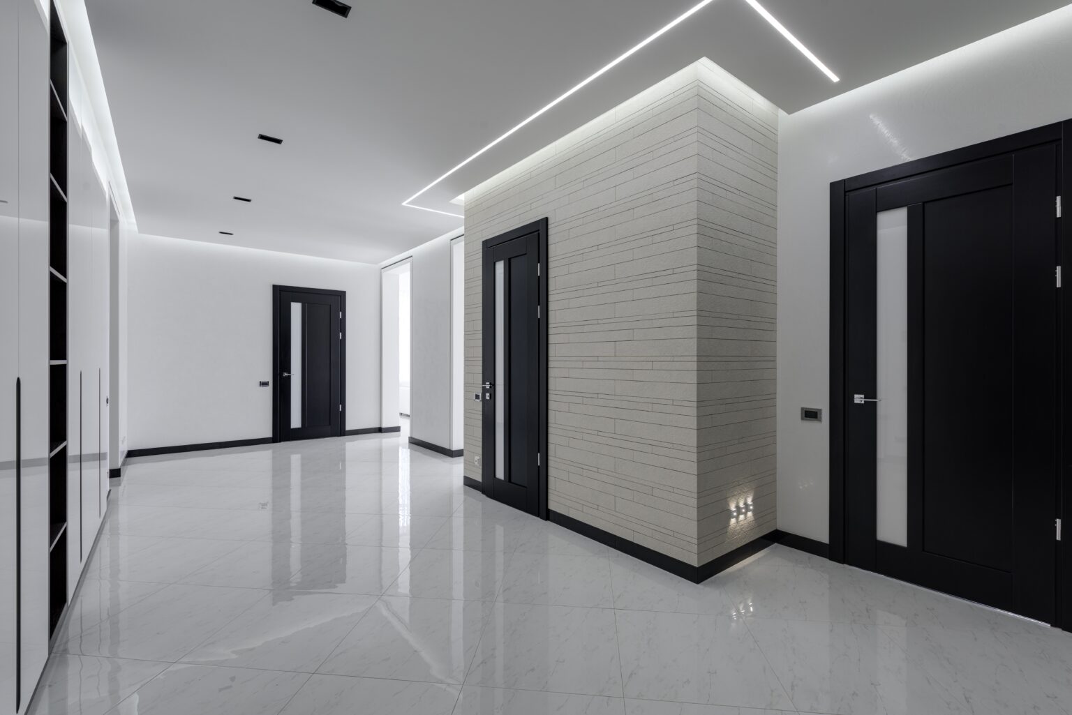 A modern with hallway with white wall grazing LED strips