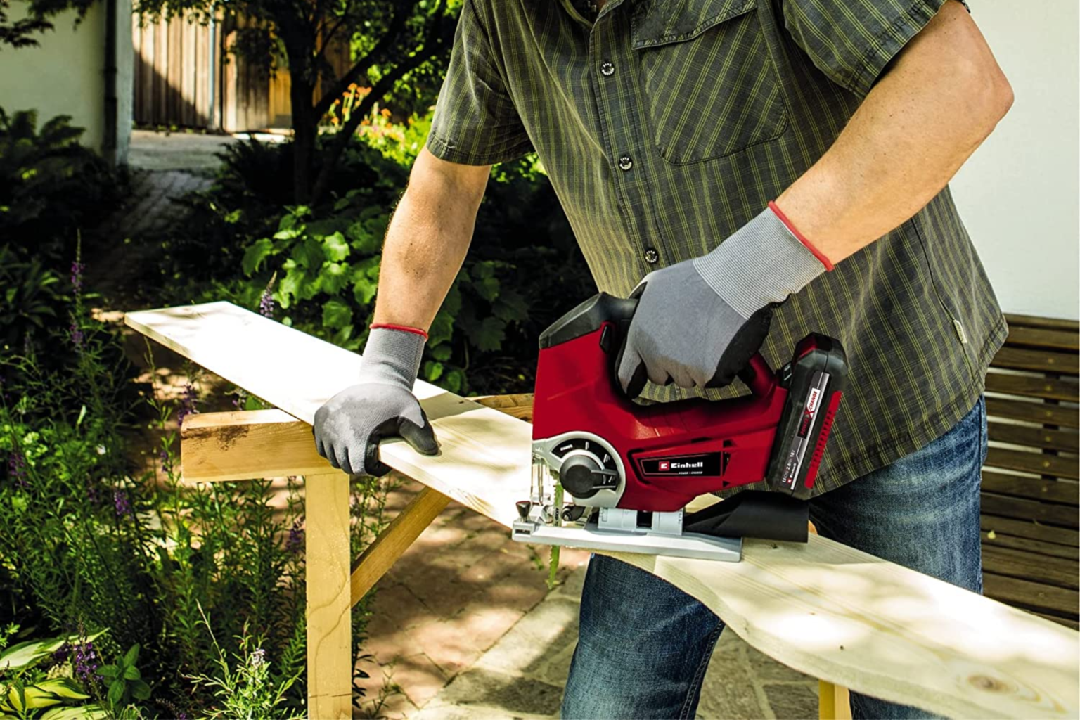 A man using a Cordless Jigsaw to cut a wooden plank