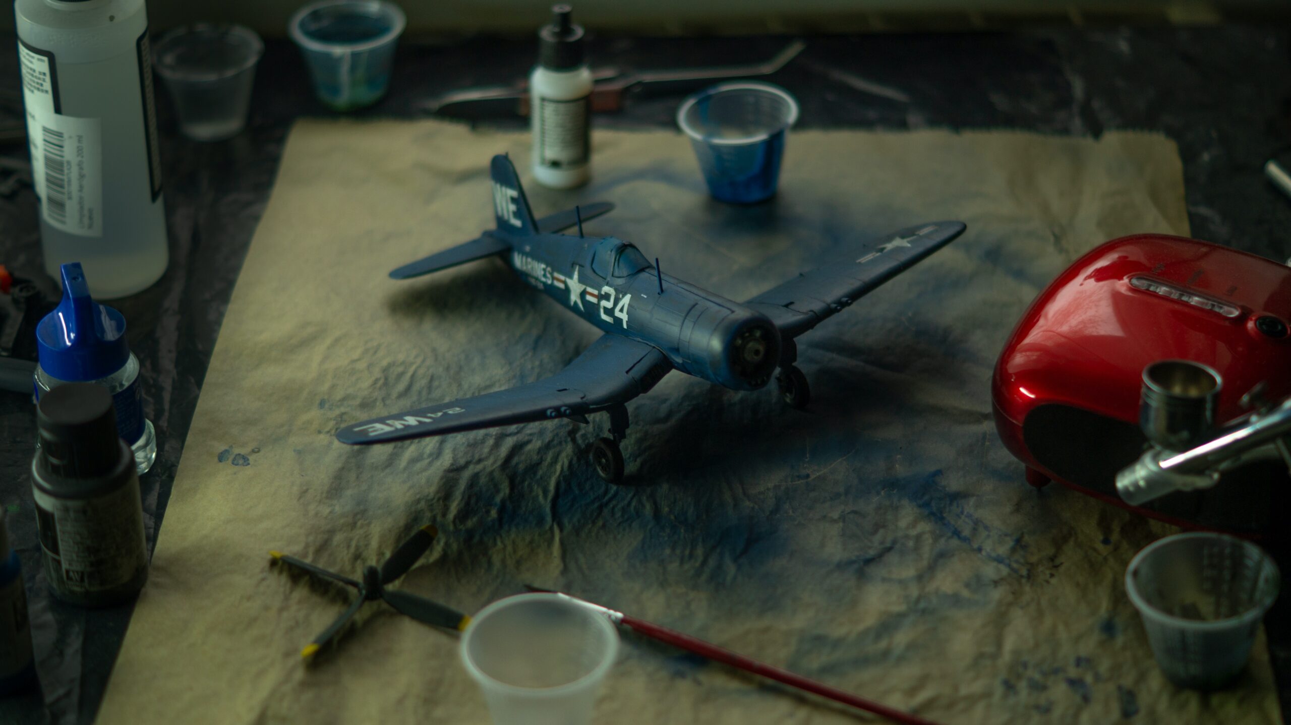 An RC plane that's just been airbrushed blue with blue paint on the paper underneath it