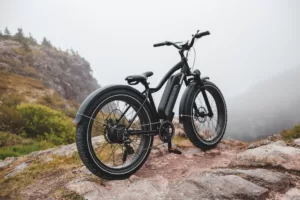 An electric bike on the top of a mountain with a foggy sky behind it