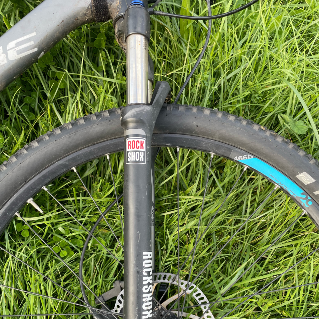 A closeup of the Rock Shox XC32 Air Forks with grass in the background