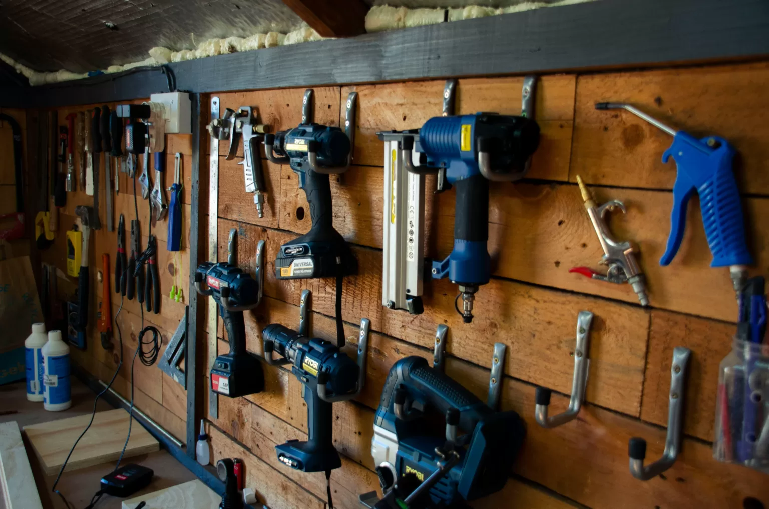 A wall with tools hanging on it in a shed